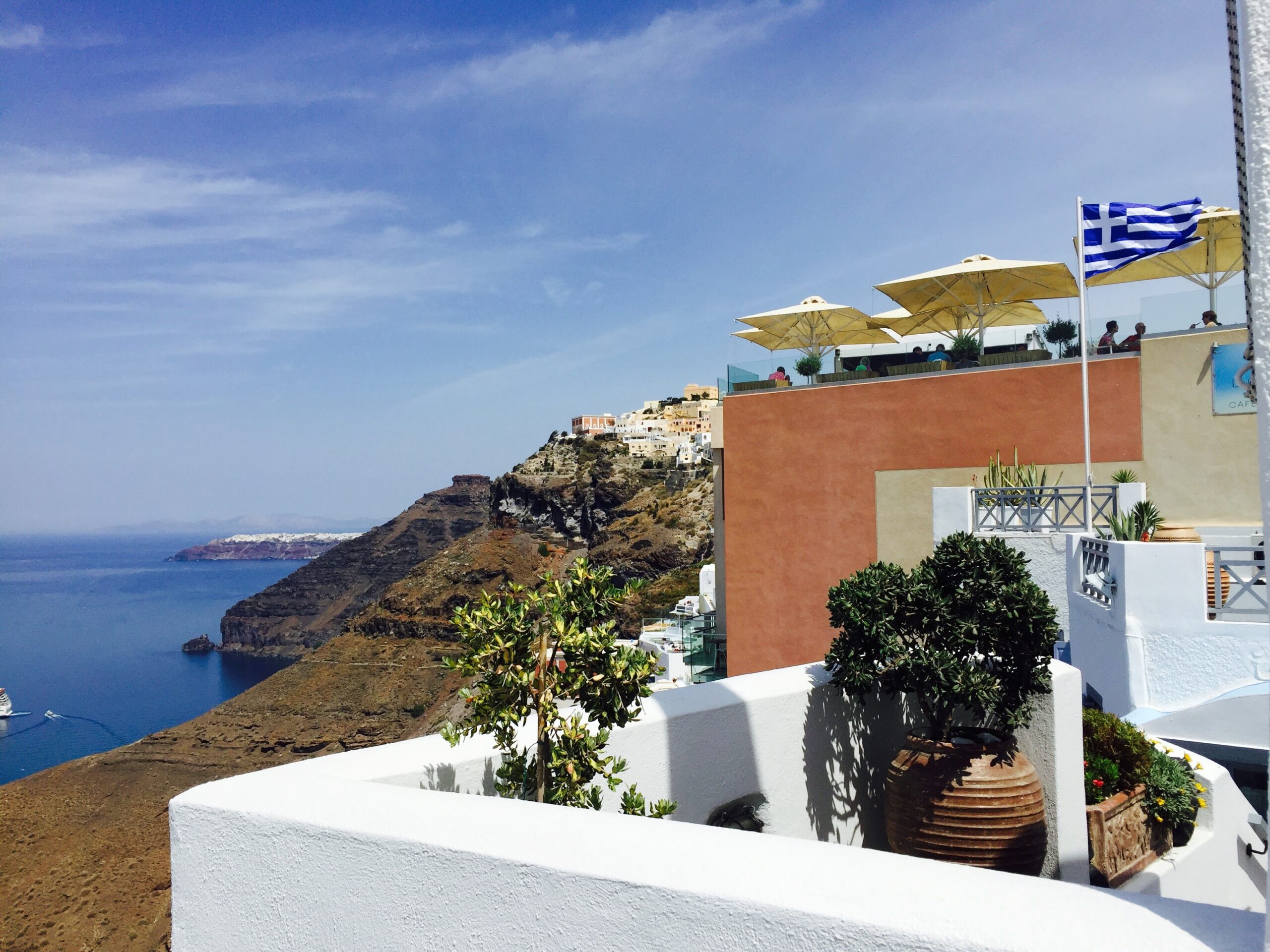 サントリーニ島のフィラの街のギリシャの国旗が立つ白い建物